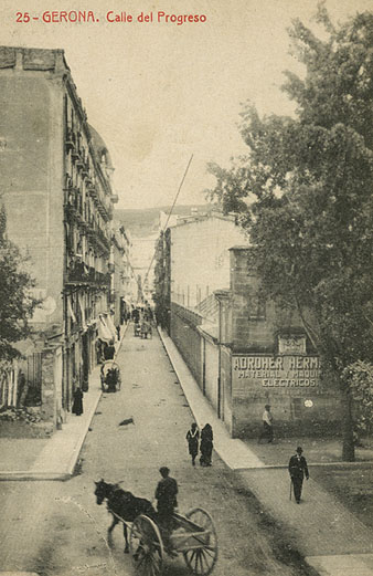 Vista del carrer Nou, a l'altura de la cruïlla amb la Gran Via de Jaume I. A l'esquerra, les cases del projecte Barnoya. A la dreta, un anunci de Adroher Germans pintat al mur. 1920