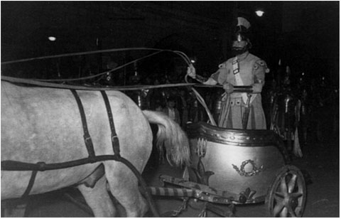 La biga a la desfilada del Xè aniversari, el Dimecres Sant de lany 1950, a la plaça del Vi, amb lauriga Ricard Fina arriant els cavalls per emprendre la pujada del Pont de Pedra