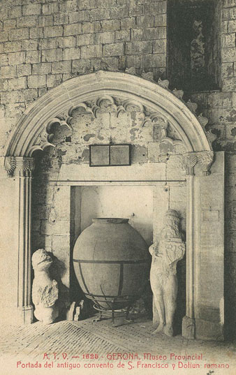 Detall de l'estructura d'una porta del convent de Sant Francesc conservada en una galeria del claustre del monestir de Sant Pere de Galligants, seu del Museu d'Arqueologia. Sota la porta, un recipient ceràmic d'orígen romà conegut amb el nom de dolium