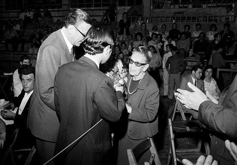 Proclamació del Premi de novel·la catalana Prudenci Bertrana al Pavelló d'Esports de la Devesa a Girona. Aurora Bertrana rebent un ram de flors de mans del regidor Fèlix Romeu. A la dreta, el periodista, Enric Frígola entrevistant-la. 13/06/1970