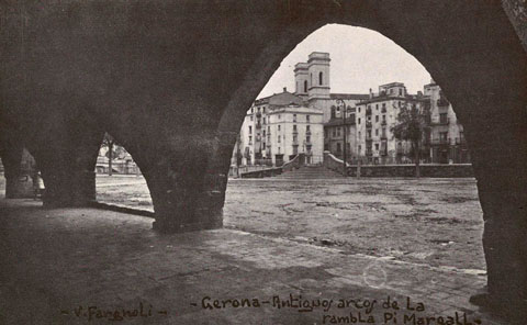 Antiguos arcos de la rambla Pi i Margall. Posteriorment despareguts en part. Al fons, el pont del Pes de la Palla i l'església del Sagrat Cor. 1913-1936