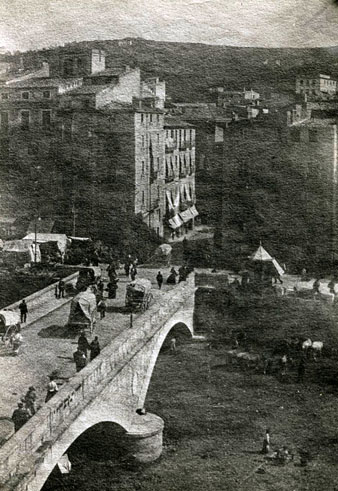 Vista des d'un punt enlairat del pont de Pedra i de l'Areny amb el mercat del bestiar bov. S'hi observa el quiosc de begudes. 1910