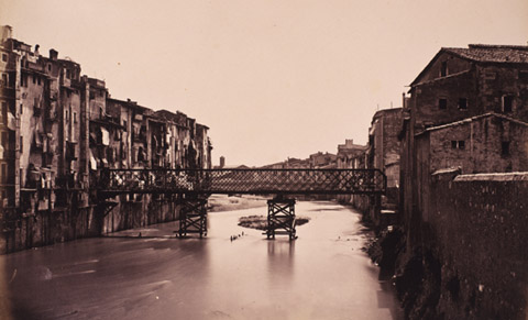 El pont de les Peixateries Velles, sobre el riu Onyar, en fase de construcció. Al fons, el convent de Sant Francesc de Paula. 1877