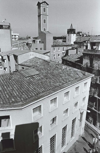 Façana de la Central Elèctrica El Molí amb la torre de les Aigües i el campanar de l'església de Santa Susanna al fons. 1993