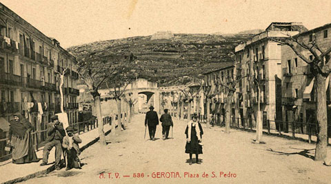Vista de la plaça de Sant Pere amb el portal de França al fons. Darrera seu la muntanya de Montjuïc, on destaquen al centre la Torre de Sant Joan i a la dreta el castell homònim. 1900-1909
