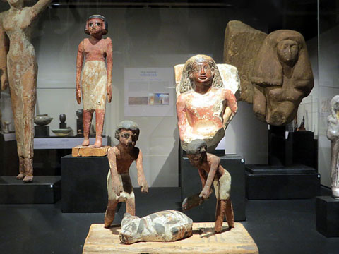 En primer terme, maqueta funerària d'uns carnissers a punt d'esquarterar un cap de bestiar. Fusta. Dinasties XI-XII (2134-1783 aC)